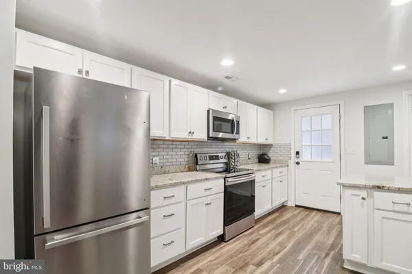a kitchen with white cabinets and stainless steel appliances