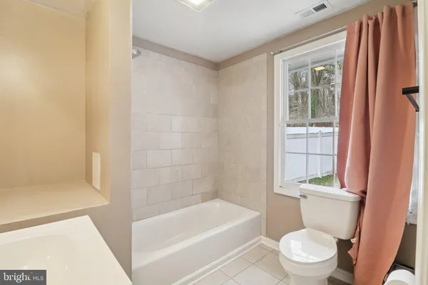 a white toilet sitting next to a bath tub