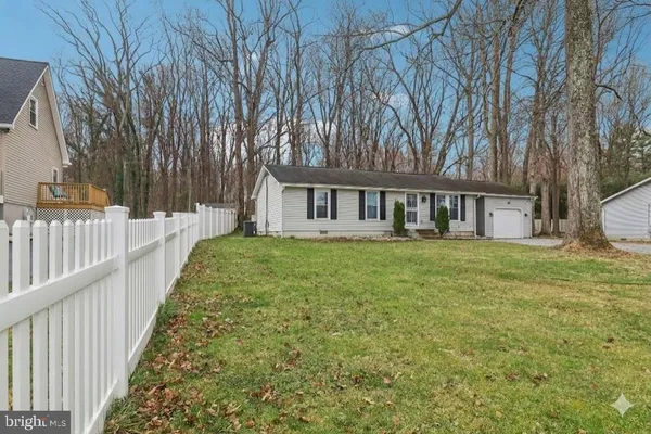 a view of a house with backyard and trees