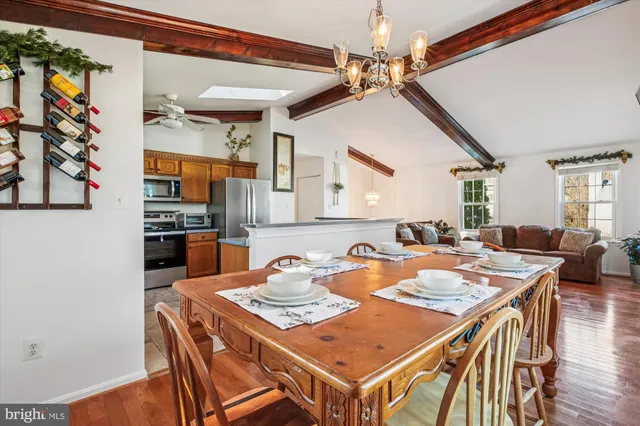 a kitchen with stainless steel appliances granite countertop a refrigerator a stove and a sink with wooden cabinets