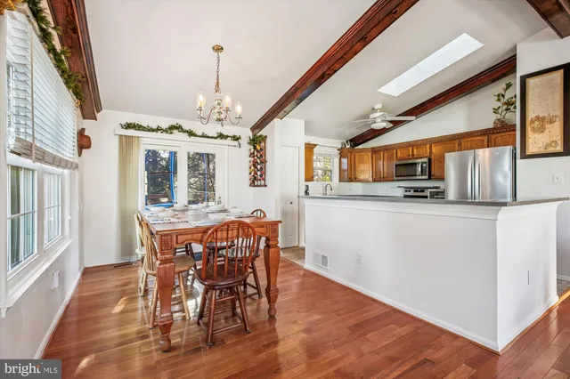 view of a kitchen with stainless steel appliances granite countertop a sink and a refrigerator