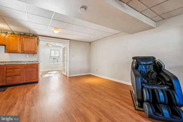 a bedroom with wooden floor a ceiling fan and a bathroom