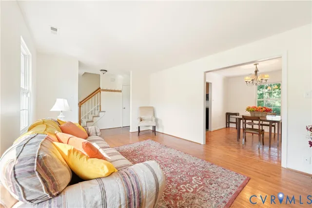 a view of an empty room with chandelier fan and fire place