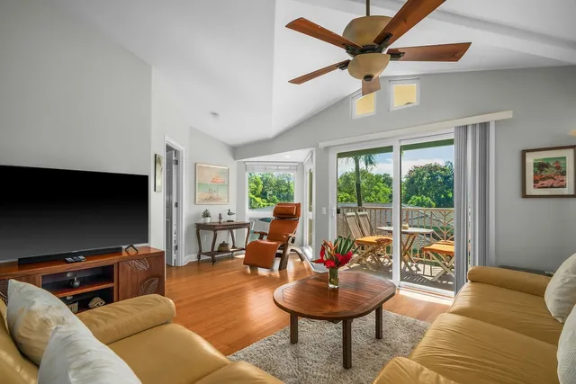 a living room with furniture a flat screen tv and a large window