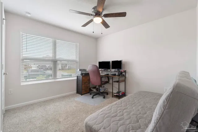 a view of a workspace with furniture and a window