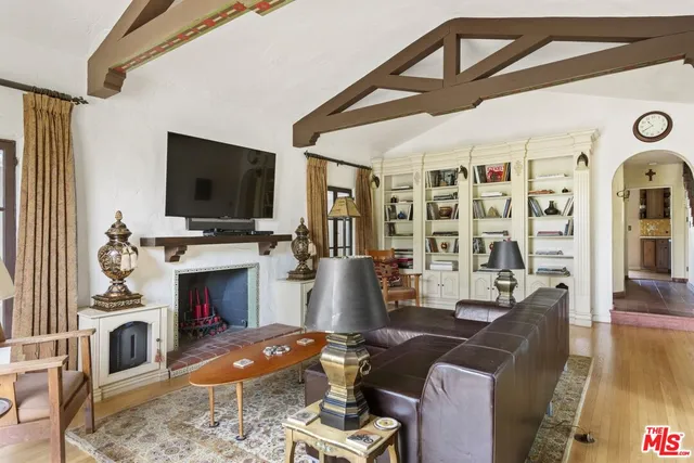a living room with furniture a fireplace and a floor to ceiling window