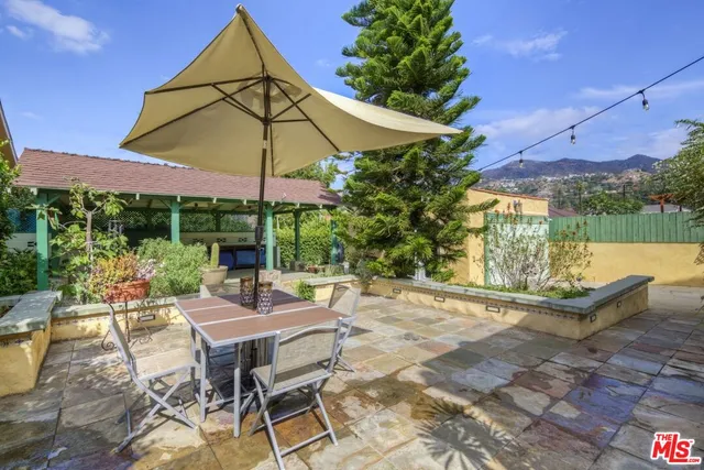 a view of patio with table and chairs under an umbrella