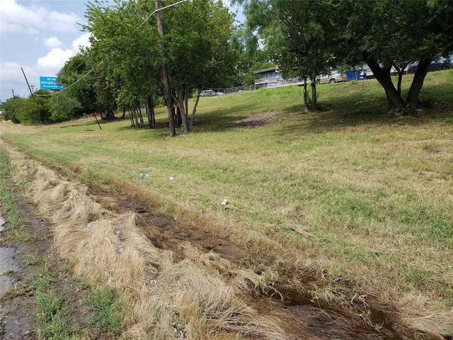 a view of three trees with a yard