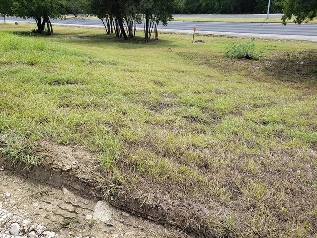 a view of swimming pool with lawn chairs and large trees