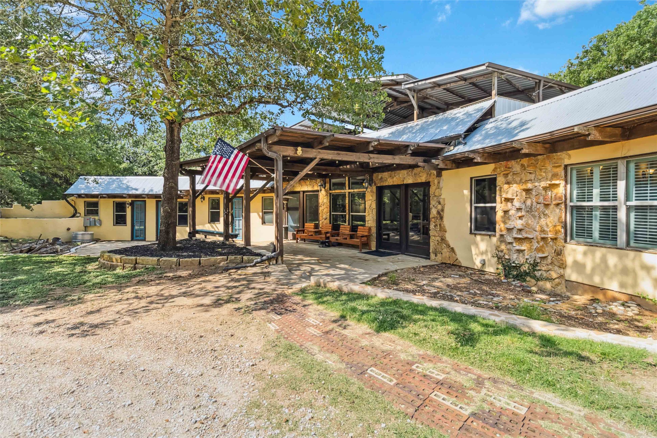 208 Old Potato Road Paige, TX 78659 - Photo 4 of 40 Front of property featuring a patio area, stone siding, and stucco siding