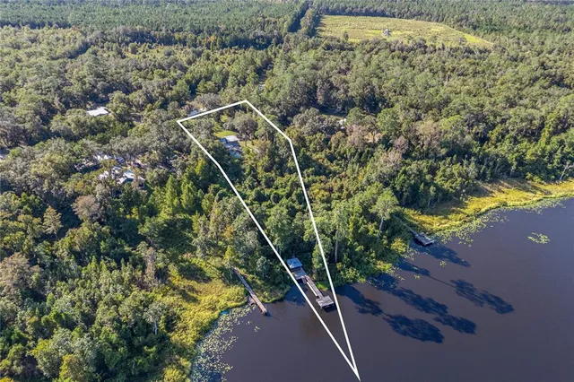 a view of a house with a big yard and large trees
