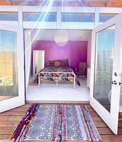 a walk in closet with wooden floor