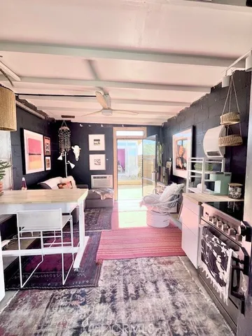a living room with furniture a rug and kitchen view
