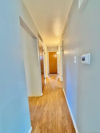a view of a hallway with wooden floor