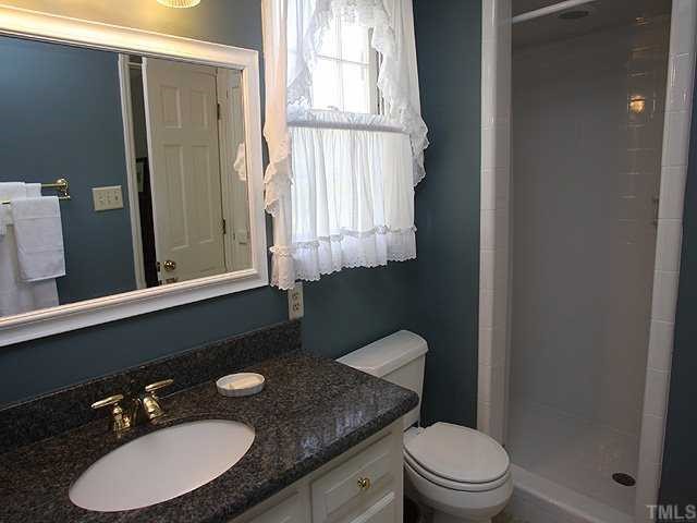 8609 Maidstone Court Raleigh, NC 27613 - Photo 8 of 12 a bathroom with a granite countertop sink toilet a mirror and shower