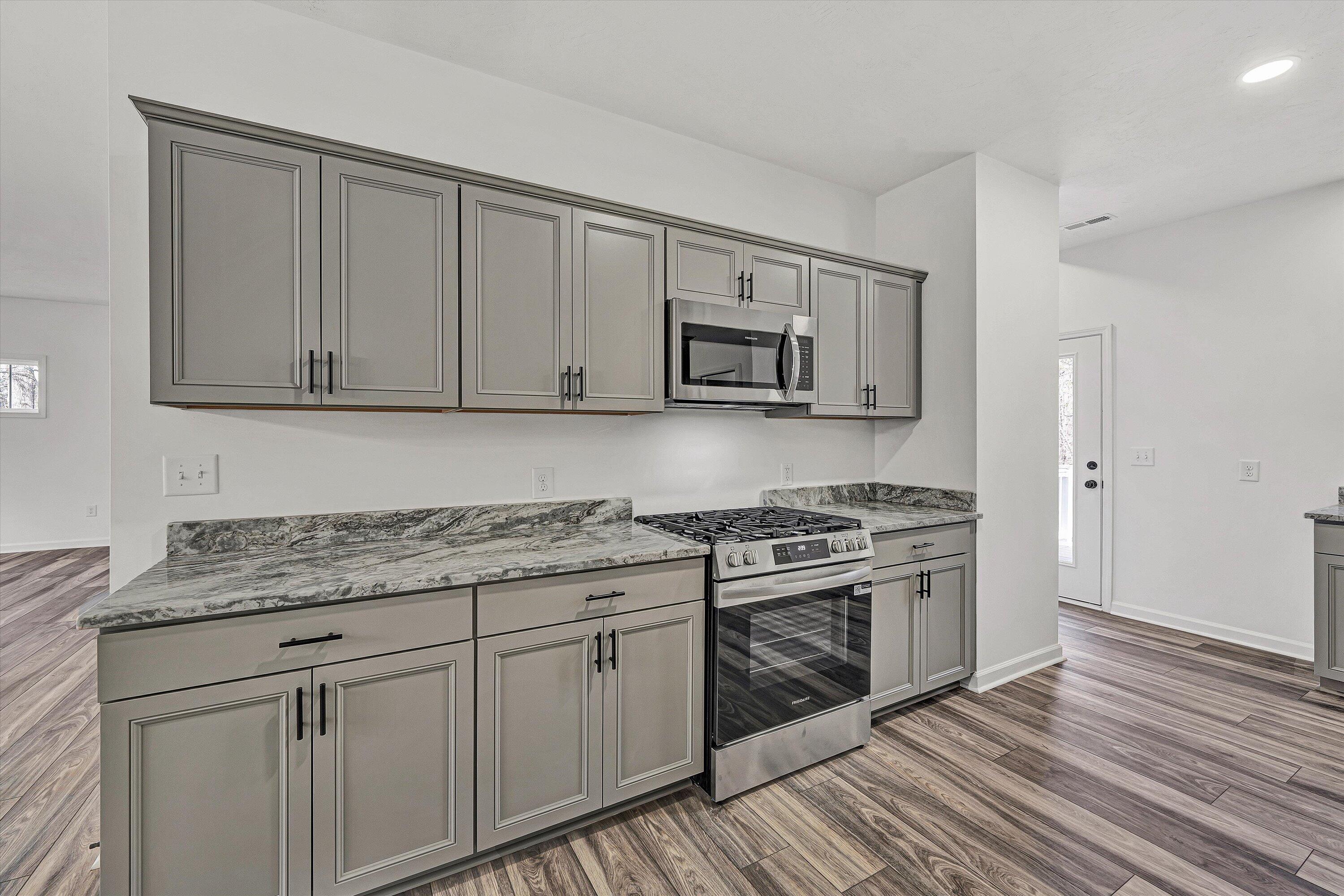103 Bluff Court Moneta, VA 24121 - Photo 11 of 63 a kitchen with granite countertop a stove top oven microwave and cabinets