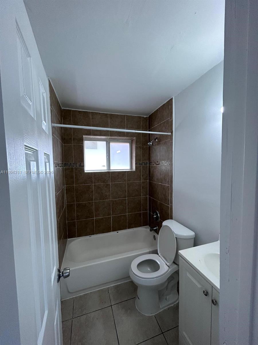 1128 Northwest 76th Street Miami, FL 33150 - Photo 12 of 25 a bathroom with a toilet a sink and shower