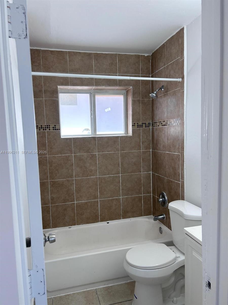 1128 Northwest 76th Street Miami, FL 33150 - Photo 13 of 25 a bathroom with a toilet and shower