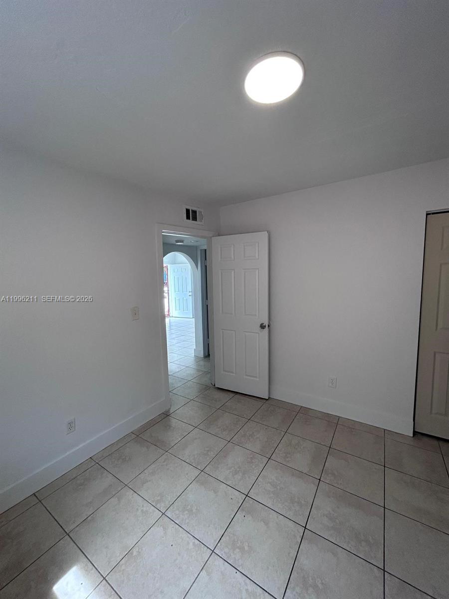 1128 Northwest 76th Street Miami, FL 33150 - Photo 14 of 25 a view of an empty room with a window