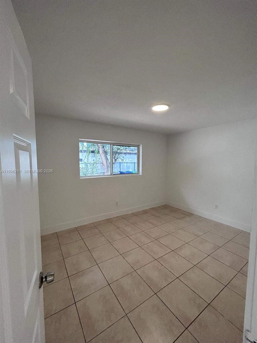 1128 Northwest 76th Street Miami, FL 33150 - Photo 15 of 25 a view of an empty room and window
