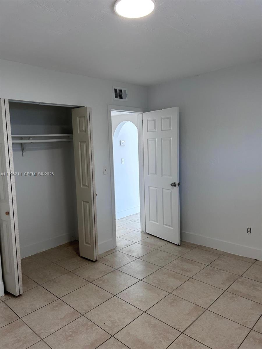 1128 Northwest 76th Street Miami, FL 33150 - Photo 17 of 25 an empty room with closet