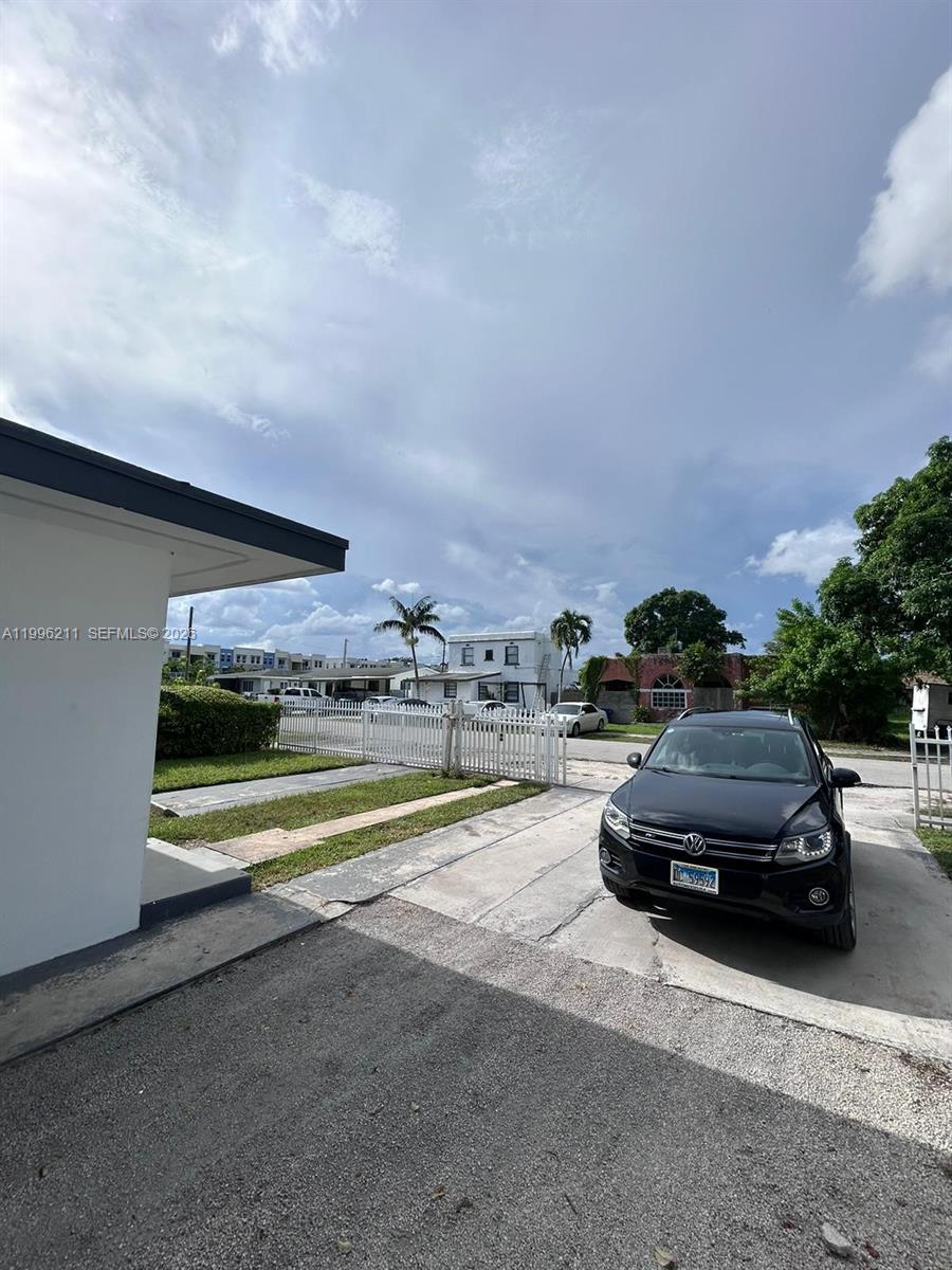 1128 Northwest 76th Street Miami, FL 33150 - Photo 21 of 25 a view of city street with a car parked on the road