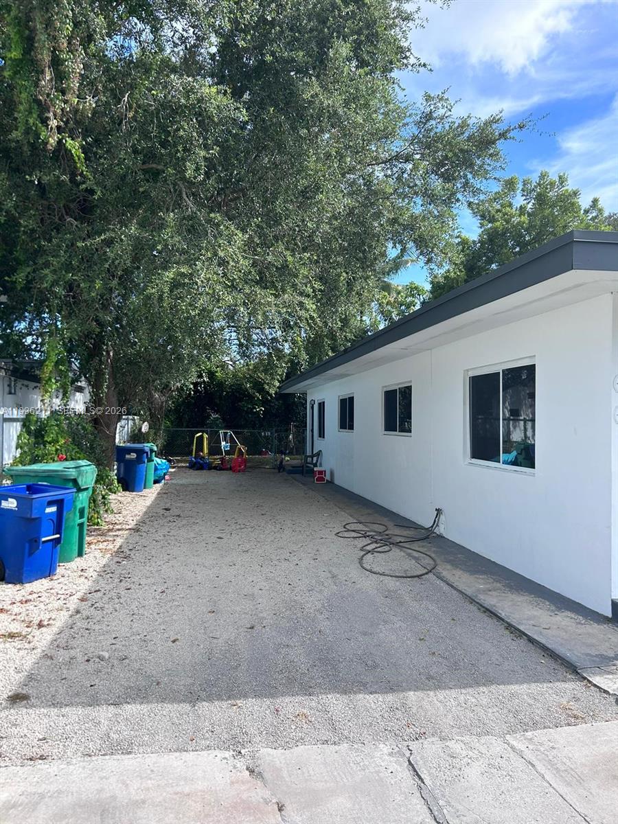 1128 Northwest 76th Street Miami, FL 33150 - Photo 25 of 25 a backyard of a house with barbeque oven and outdoor seating