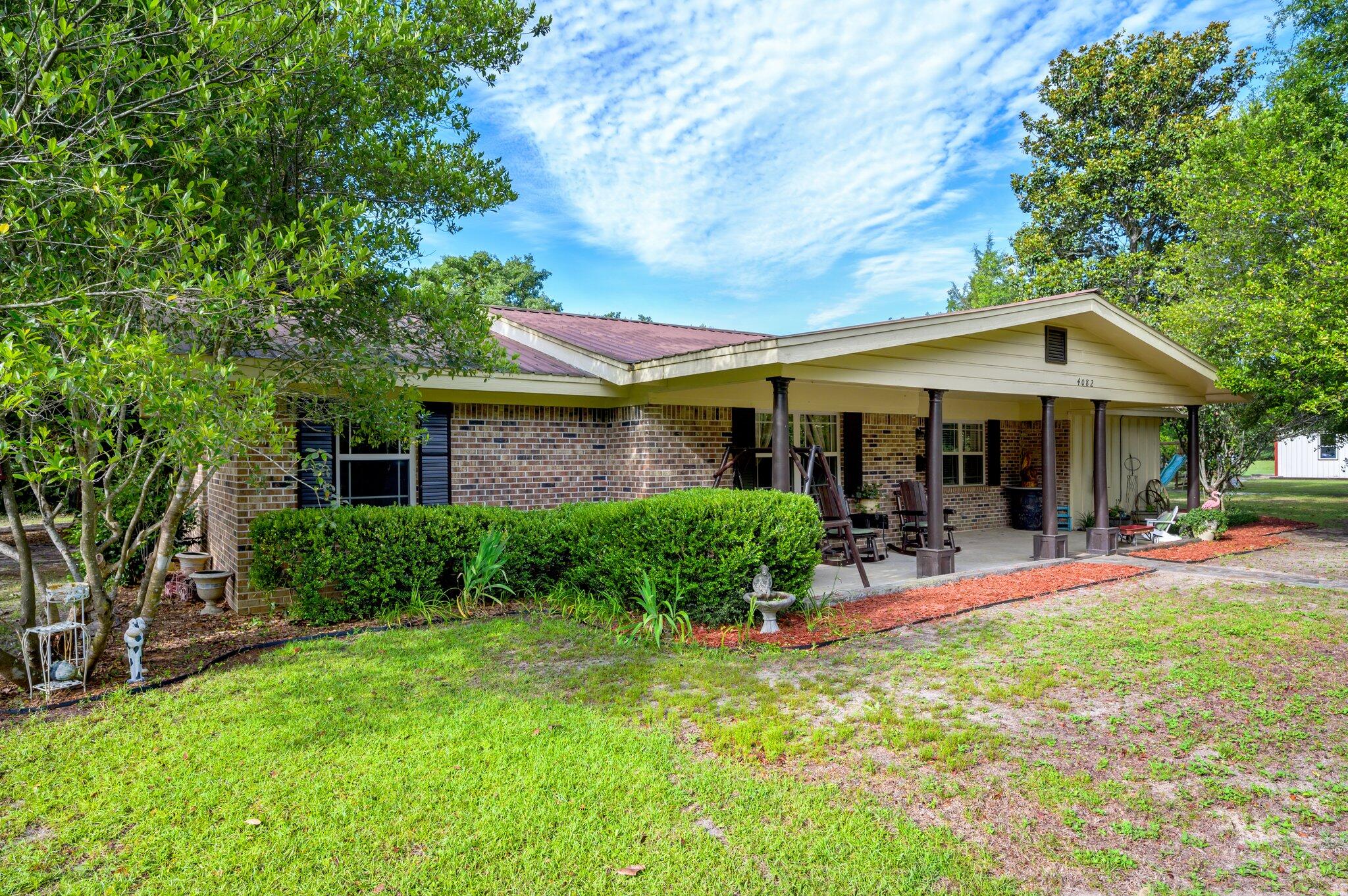 4082 Painter Branch Road Crestview, FL 32539 - Photo 2 of 49 a front view of a house with swing and yard