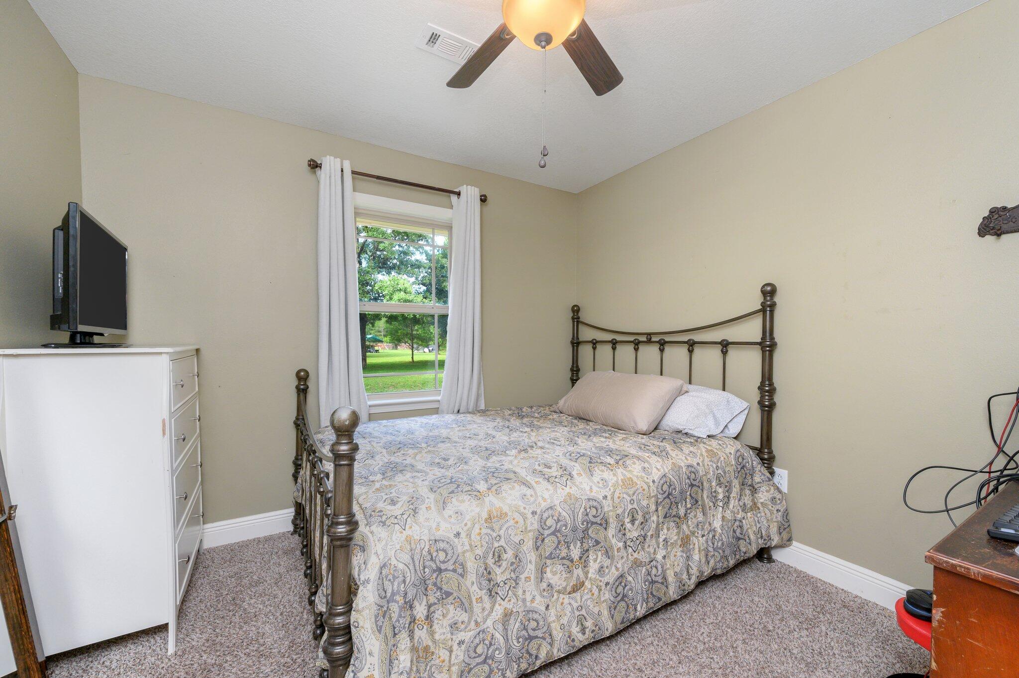 4082 Painter Branch Road Crestview, FL 32539 - Photo 27 of 49 a bedroom with a bed a flat screen tv and a chandelier