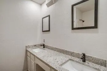 a bathroom with a granite countertop sink and a mirror