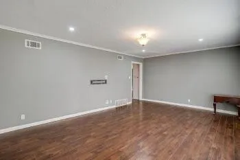 a view of an empty room with wooden floor