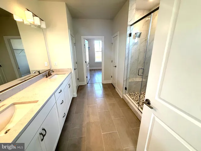 a bathroom with a double vanity sink and mirror with bathtub