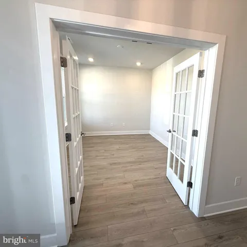 a view of a hallway with wooden floor and staircase