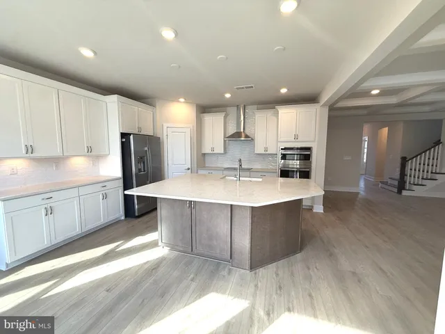a large kitchen with kitchen island a sink a center island stainless steel appliances and a cabinets