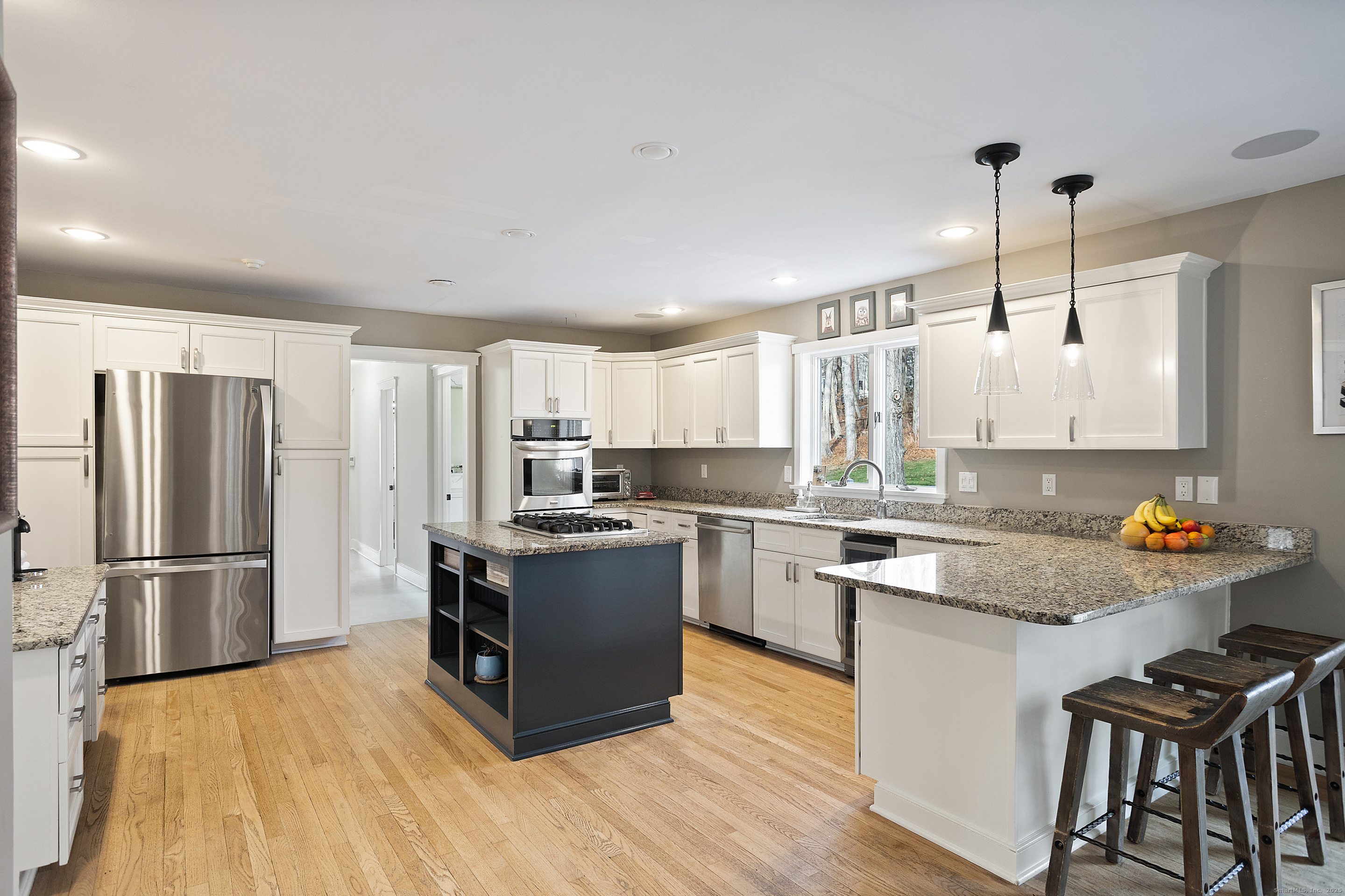 41 Deer Hill Road Redding, CT 06896 - Photo 9 of 31 a kitchen with stainless steel appliances granite countertop a refrigerator a sink dishwasher a stove and white countertops with wooden floor