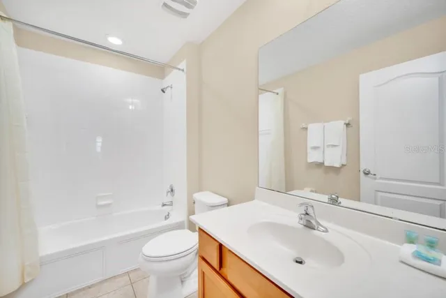 a bathroom with a sink a toilet a mirror and shower
