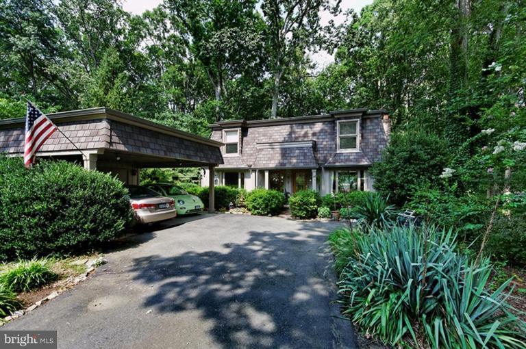 12104 Stirrup Road Reston, VA 20191 - Photo 2 of 27 a front view of a house with a garden and trees