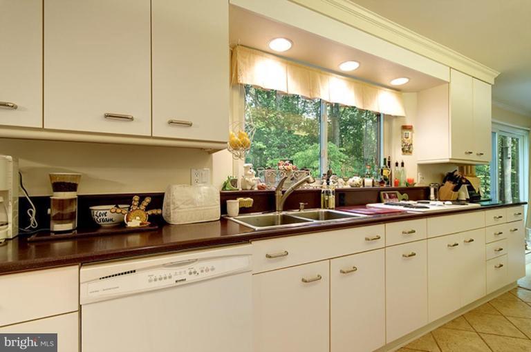 12104 Stirrup Road Reston, VA 20191 - Photo 12 of 27 a kitchen with white cabinets and a window