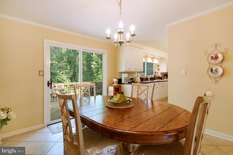 12104 Stirrup Road Reston, VA 20191 - Photo 9 of 27 a view of a dining room with furniture a chandelier and wooden floor