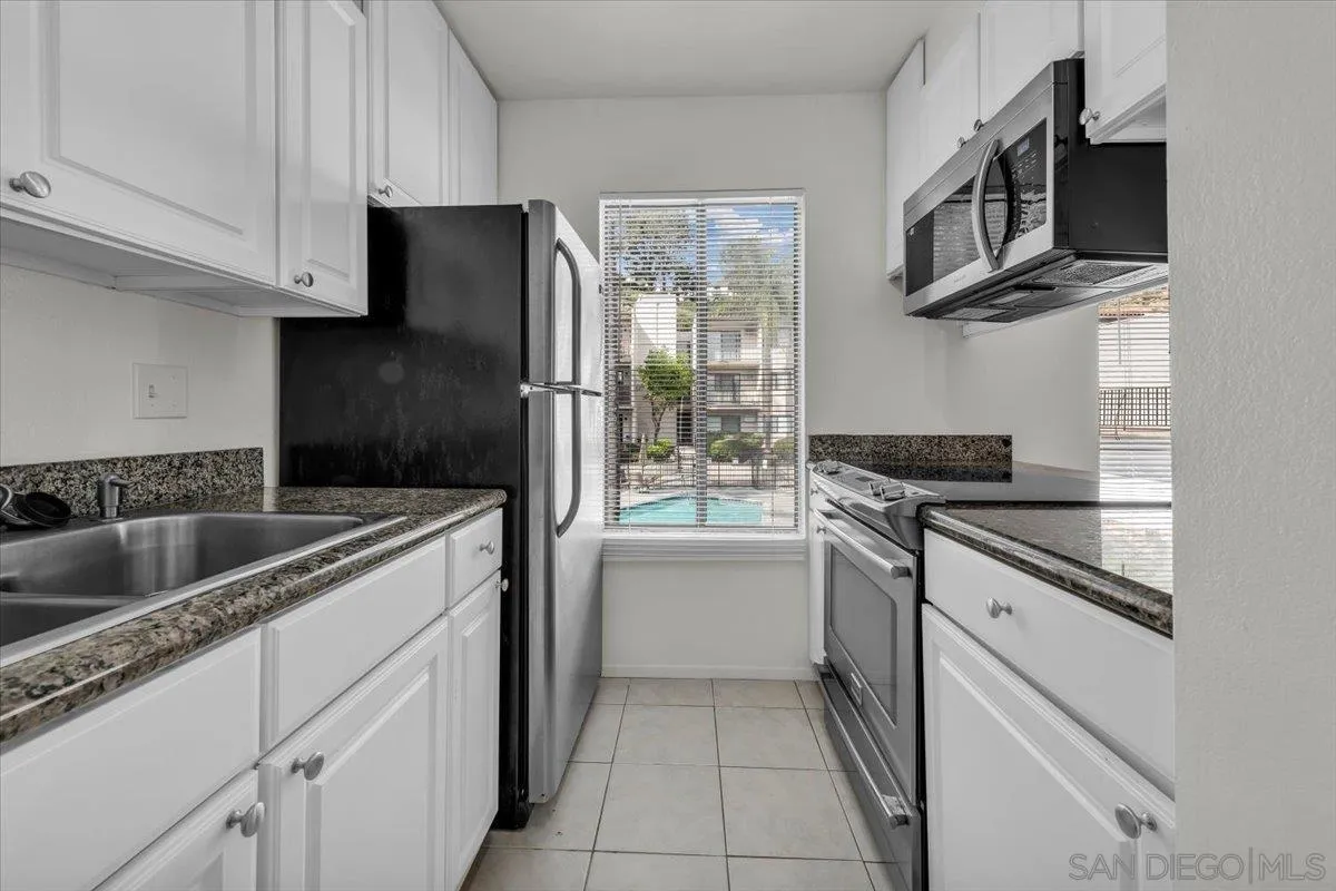6780 Friars Road, Unit 214 San Diego, CA 92108 - Photo 16 of 23 a kitchen with stainless steel appliances granite countertop a refrigerator and a sink