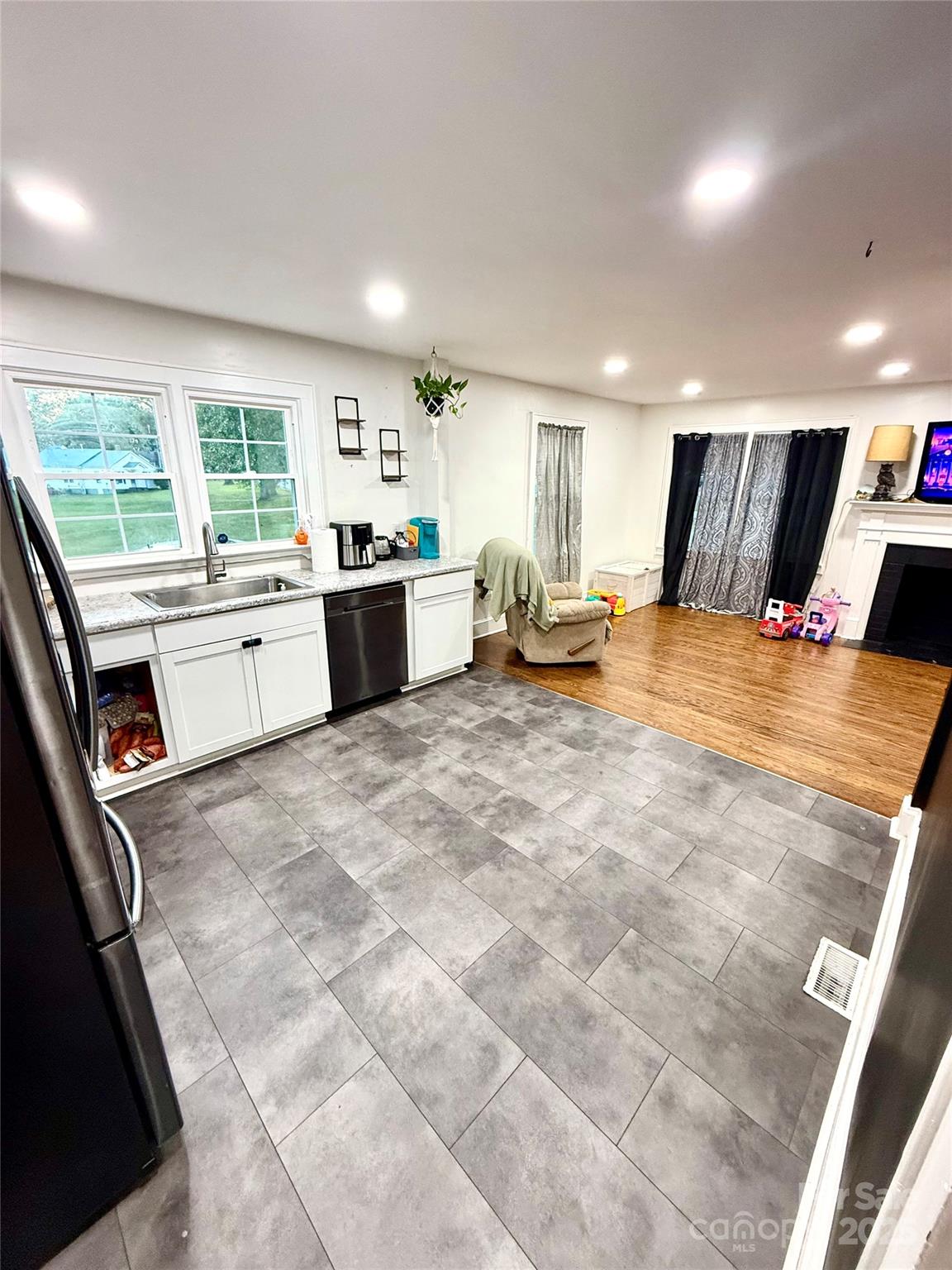 245 Church Street Ellenboro, NC 28040 - Photo 6 of 18 a large white kitchen with kitchen island a stove a sink dishwasher and cabinets with wooden floor