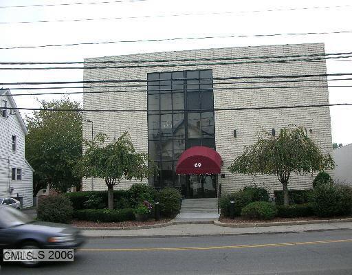 69 Cove Road, Unit B14 Stamford, CT 06902 - Photo 1 of 1 a front view of a house with a garden