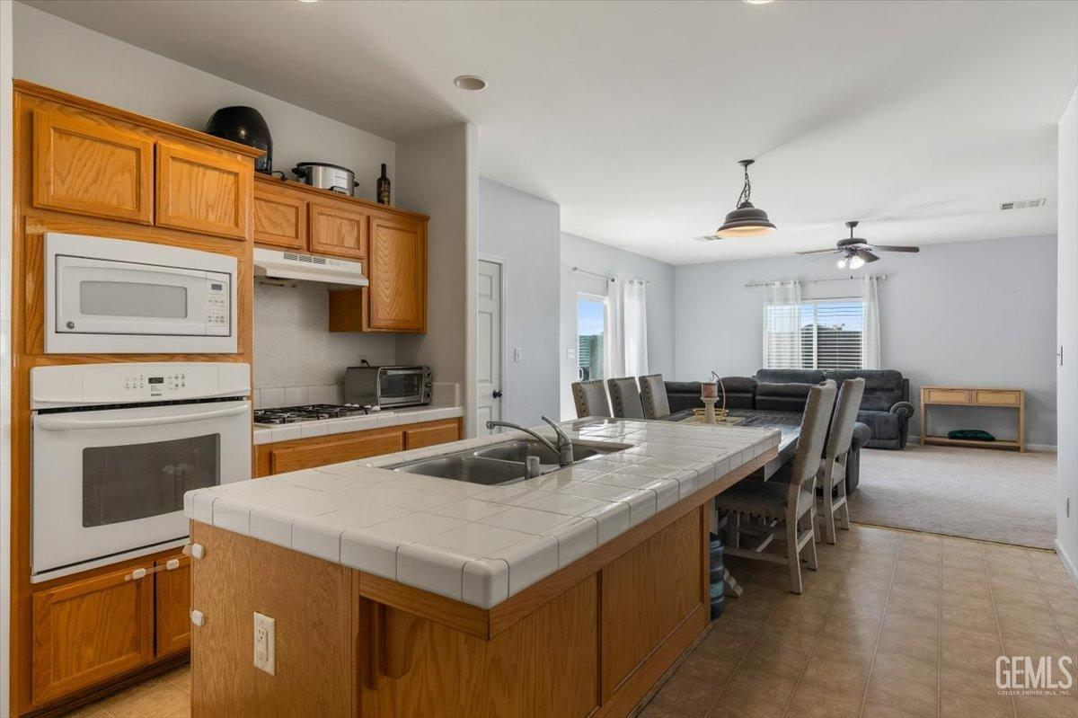 Undisclosed Address Shafter, CA 93263 - Photo 4 of 11 a kitchen with a stove a sink and a refrigerator