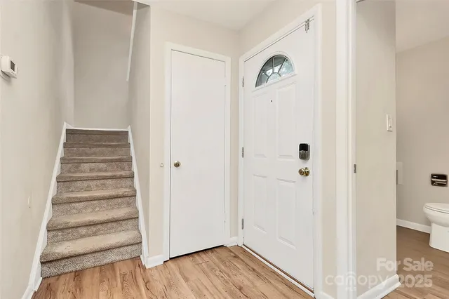 a view of a hallway with wooden floor and closet