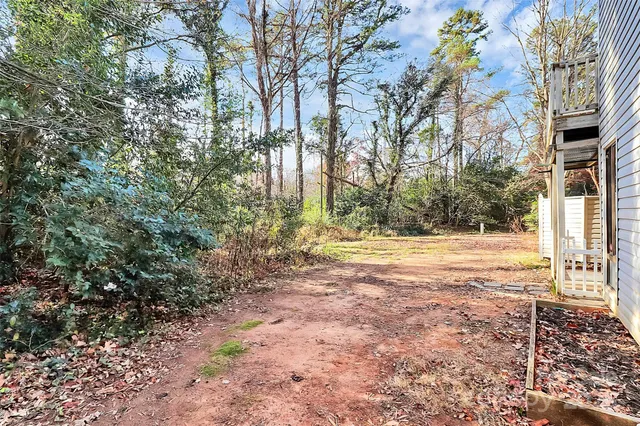 a view of a house with a large window and flower plants