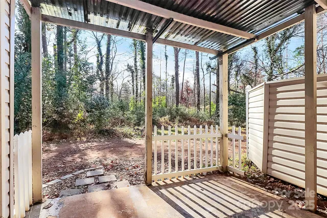 a view of a small house covered with trees in the background