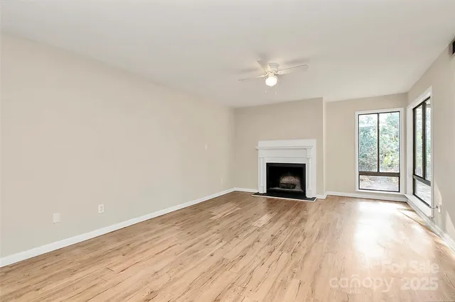 a view of an empty room with a fireplace and a window