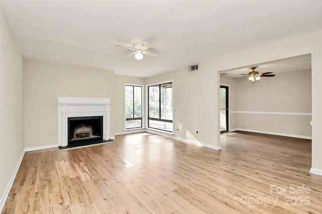 wooden floor fireplace and windows in an empty room
