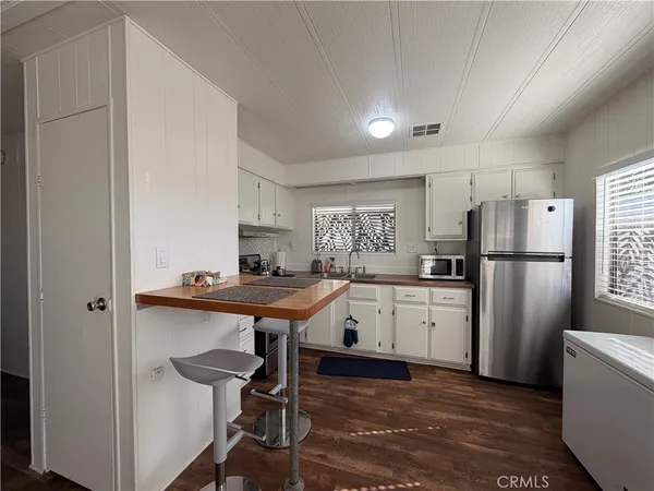 a kitchen with refrigerator cabinets and wooden floor