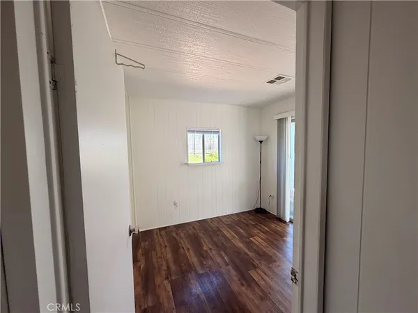 a view of an empty room with closet and a window